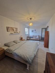 a bedroom with a large bed and a living room at Villa de standing proche d'Argelès sur Mer in Saint-André