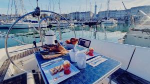 une table sur un bateau avec un ordinateur portable dessus dans l'établissement Coriandre 2 - Dormir sur un grand voilier 9 personnes By Nuits au Port, à La Rochelle