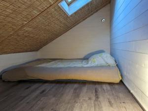 a bed in a small room with a wooden floor at cabane in Ile d'Arz