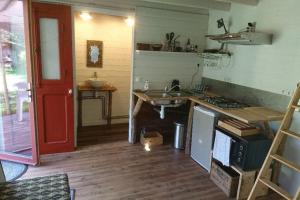 a kitchen with a sink and a red door at cabane in Ile d'Arz