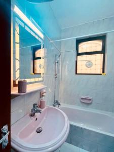 a white bathroom with a sink and a bath tub at Spacious family friendly apartment - Free Barking in Amman