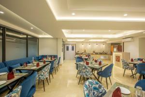 un restaurante con mesas y sillas azules y una cafetería en OPO Hotel Iffco Chowk en Gurgaon