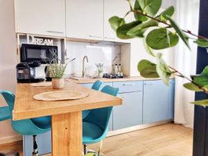 a kitchen with a wooden table and blue chairs at Mandala - Studiouri si Apartamente in Eforie Nord