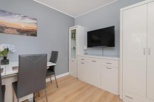 a white room with a desk and a tv on a wall at Unique Apartment with a Balcony in Sopot by Rent like home in Sopot