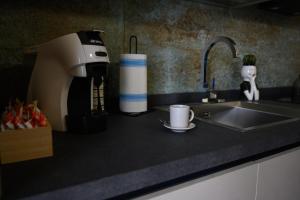 un bancone della cucina con macchinetta del caffè e lavandino di INCAO HOLIDAY LA STRUMMULA HOUSE a Cefalù