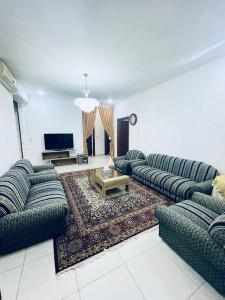 a large living room with couches and a television at Spacious family friendly apartment - Free Barking in Amman