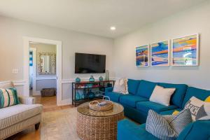 sala de estar con sofás azules y TV en Walk to Ryder Cove Wet Bar & Hot Tub, en Chatham