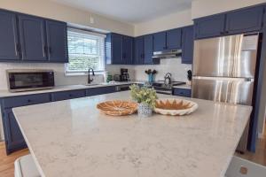 a kitchen with blue cabinets and a marble counter top at Perfect for Group w Kids & Dogs w Hot Tub in Chatham