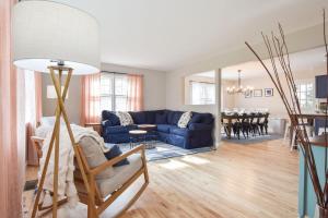 a living room with a blue couch and a dining room at Perfect for Group w Kids & Dogs w Hot Tub in Chatham