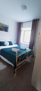 um quarto com uma cama com lençóis azuis e uma janela em Home Sea of Serenity em Ston