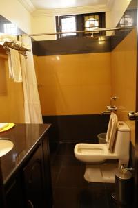 a bathroom with a white toilet and a sink at Malanadu Tourist Home in Hosdrug