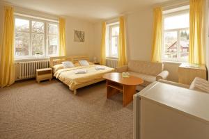 sypialnia z łóżkiem, kanapą i stołem w obiekcie Penzion a restaurace na Křižovatce w mieście Polevsko