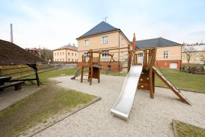 een speeltuin met een glijbaan in een park bij Penzion a restaurace na Křižovatce in Polevsko