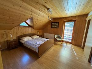 ein Schlafzimmer mit einem Bett in einer Holzhütte in der Unterkunft Chill on Hill - Szczyrk in Szczyrk