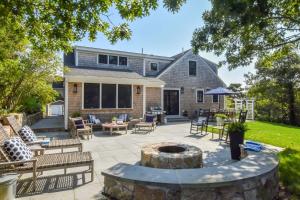 a patio with a fire pit in front of a house at Gorgeous Home 2 Min Walk to Beach in Harwich