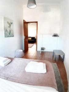 a bedroom with a bed with white sheets and a table at 4 bedrooms apartement with city view balcony and wifi at Porto 3 km away from the beach in Porto