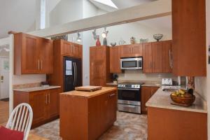 a large kitchen with wooden cabinets and appliances at Pond Front Home with Private Dock in Brewster
