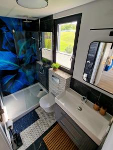 a bathroom with a tub and a sink and a toilet at Lisi Ogon zanurzeni w naturze in Lisi Ogon