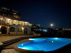 a large blue swimming pool in front of a building at night at Complex Bolyarsko selo & Spa Arbanasi in Arbanasi