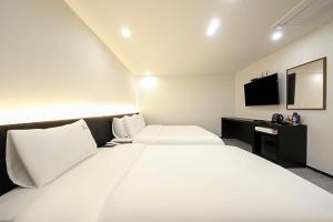 Postel nebo postele na pokoji v ubytování Busan Seomyeon Broa Hotel