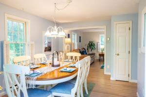 a dining room and living room with a table and chairs at Full Sand Volleyball Court Walk to Pond in Brewster