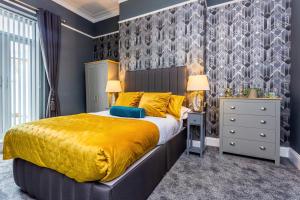 a bedroom with a large bed with a yellow bedspread at Room 01 - Sandhaven Rooms - Double in South Shields