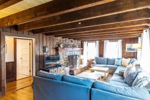 a living room with a blue couch and a fireplace at Heated Pool AC 1 2 Mile to Beach in Harwich