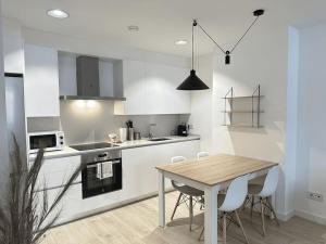 a kitchen with a wooden table and white cabinets at New Port, Free Parking YBH1S in Vigo