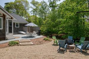 a backyard with chairs and a table and a grill at Spacious Home by Beach Dog Welcome in Brewster