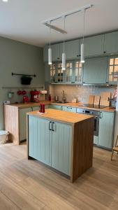 a kitchen with blue cabinets and a wooden counter top at Apartament Pastelove Żywiec in Żywiec