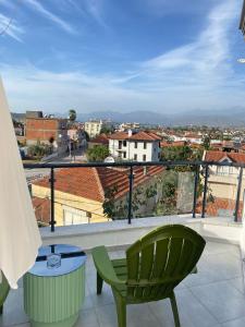 a balcony with a green chair and a view of a city at 9 House in Fethiye
