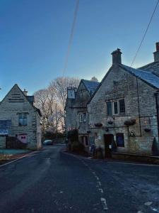 an old stone building on the side of a street at BEAR INN - BISLEY in Bisley