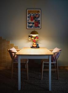 a dining room table with a lamp and two chairs at Apfelhof Biesenbrow in Biesenbrow