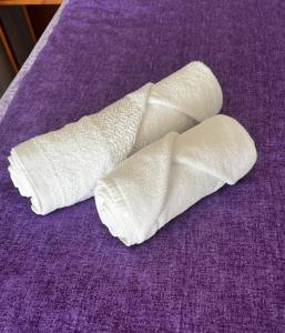 a pair of white bandages on a purple bed at Apartment R&eacute;v&eacute;sz in Hark&aacute;ny