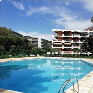 una gran piscina frente a un edificio en Bel appartement en résidence avec 3 piscines, en Mandelieu-la-Napoule