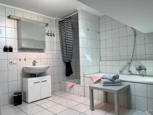 a white bathroom with a sink and a tub and a sink at Allgäutraum Ferienwohnung Nr. 2 in Kempten