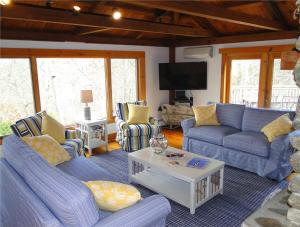 sala de estar con sofás azules y TV en Steps to Freshwater Beach Kayaks Sauna, en Brewster