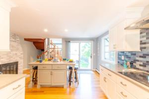 a kitchen with white cabinets and a fireplace at Water Views Private Pool Access to Cove in Dennis +40 photos