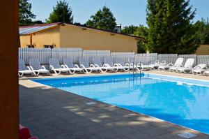 a swimming pool with lounge chairs and a fence at Apartament z Widokiem na Morze - Błękitna Perła by Perłowa Przystań Rent in Sianozety