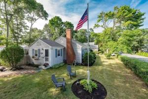 une maison arborant un drapeau américain dans la cour dans l'établissement Walk 3 Mins to Private Assoc Beach, à Yarmouth