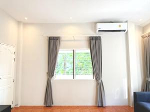 a window with curtains in a living room at Prime Hill Kathu Phuket E1 in Phuket Town