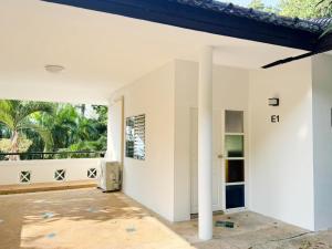 an empty white house with a large window at Prime Hill Kathu Phuket E1 in Phuket Town