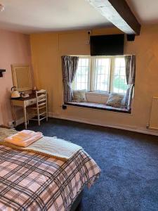- une chambre avec 2 lits et une grande fenêtre dans l'établissement BEAR INN - BISLEY, à Bisley