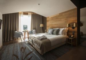a hotel room with a large bed and a table at Vale d'Azenha Hotel Rural & Residences in Alcobaça