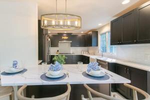 a kitchen with a table with chairs and a chandelier at In-Ground Plunge Pool Dog Friendly! in Brewster