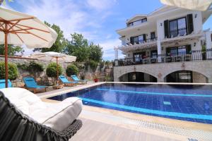 une villa avec une piscine en face d'un bâtiment dans l'établissement Villa TN - Fethiye, à Fethiye