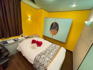 a bedroom with a bed with a red flower on it at ホテル　るテラスⅡ in Sendai