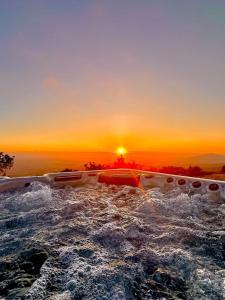 eine Badewanne im Wasser mit Sonnenuntergang im Hintergrund in der Unterkunft Fantastic villa with panoramic coastal & sea views in Estói