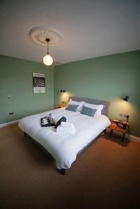 un grande letto in una camera da letto con parete verde di The Alma Taverns Boutique Suites - Room 4 - Hopewell a Bristol