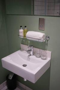 Baño con lavabo blanco y pared verde en The Alma Taverns Boutique Suites - Room 4 - Hopewell, en Bristol
